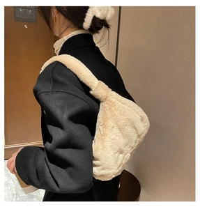 Détail d'un sac hobo en fausse fourrure crème avec large bandoulière sur l'épaule