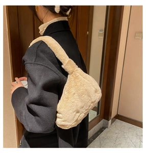 Détail de la texture douce du sac en peluche crème sur fond de manteau sombre