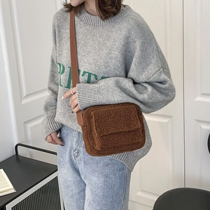 Sac bandoulière en sherpa marron avec rabat et large sangle, porté par un mannequin
