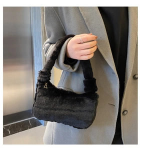 Détail d'un sac à main noir en fausse fourrure avec texture peluche et zip en métal doré