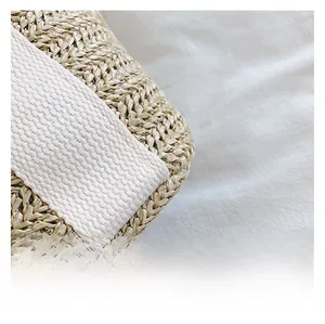 Macro shot of natural straw weaving detail with thick off-white twill ribbon strap