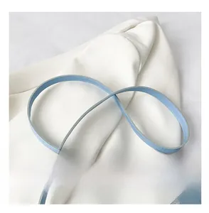 Détail de la bandoulière en similicuir bleu clair avec surpiqûres blanches