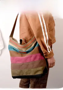 Détail d'un sac cabas en toile à rayures multicolores avec logo en cuir et bandoulière