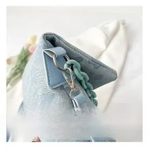 Gros plan des boucles en métal argenté et chaîne en plastique bleu sur sac jacquard