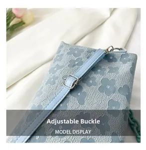 Détail de la boucle en métal réglable sur le petit sac à bandoulière bleu fleuri