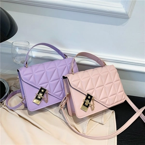 Quilted crossbody bag with gold hardware and top handle in light pink and purple tones