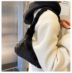 Gros plan d'un sac sous le bras en fausse fourrure noire avec une texture pelucheuse
