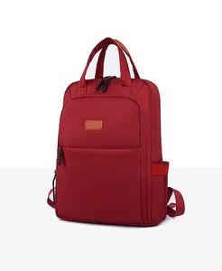 Side view of waterproof burgundy nylon backpack with top handle and zipper pocket
