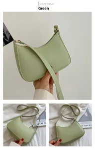 Detail of light green crescent underarm bag with gold zipper and textured faux leather
