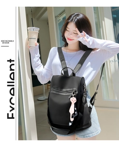 Fashionable black nylon backpack for women featuring a detachable design and cat charm