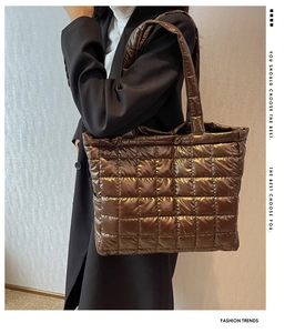 Detail of coffee gold quilted tote bag with glossy metallic finish and puffy square stitching