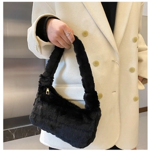 Gros plan du sac sous le bras en peluche noire avec fermeture éclair dorée et texture