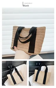 Detail view of straw tote bag with black wide webbing handles and herringbone texture
