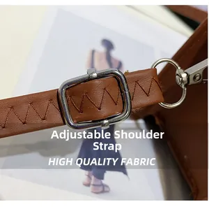Detail of adjustable brown leather shoulder strap with reinforced stitching and silver buckle