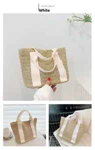 Detail of beige straw tote bag featuring a V-shaped weave pattern and white canvas handles