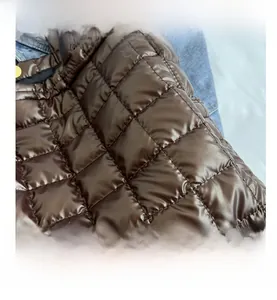 Detailed view of dark brown quilted puffer tote fabric with square stitching pattern