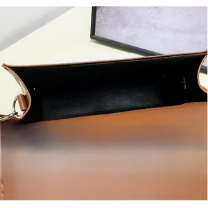Detail view of the caramel brown crossbody bag showing the black fabric lining and inner space