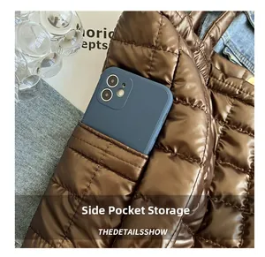 Detail showing the side storage pocket on a brown quilted tote bag with a smartphone inside