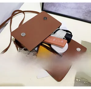Brown crossbody bag interior showing storage space for sunglasses, umbrella and cosmetics