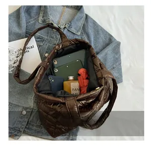 Spacious interior of brown quilted tote bag showing tablet, umbrella and water bottle