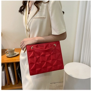 Detail of red crossbody bag with 3D geometric patterns and gold chain strap