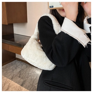 Gros plan sur la texture en fausse fourrure blanche et l'anse d'un mini sac à main