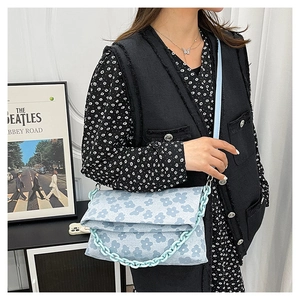 Détail du sac à bandoulière bleu clair à imprimé floral avec chaîne en plastique
