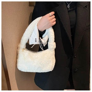 Détail du sac sous l'aisselle en fausse fourrure blanche avec texture douce et zip doré