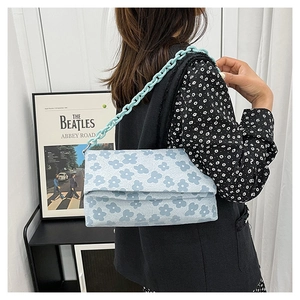 Détail du sac bandoulière bleu clair à imprimé fleuri avec bandoulière en chaîne