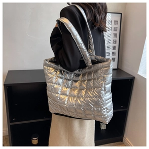 Side view of a large silver quilted tote bag on model for casual everyday commute wear
