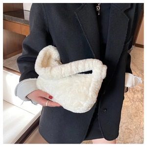 Gros plan sur le sac sous l'aisselle en peluche blanche, texture douce et fermeture éclair