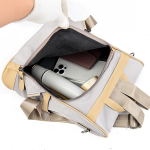 Minimalist large capacity gray nylon backpack showing interior storage for water bottle and wallet