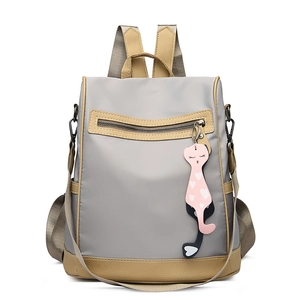 Minimalist grey water-resistant nylon backpack with khaki leather trim and cat charm