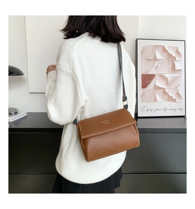 Petit sac bandoulière marron vintage avec une large sangle brodée en gros plan détaillé