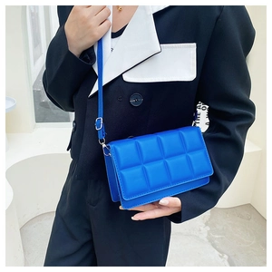 Detail of Klein blue quilted PU leather bag featuring elegant square stitching texture