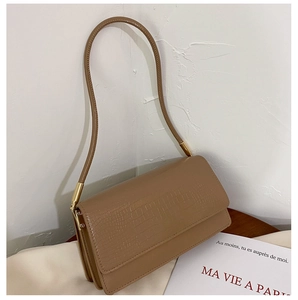 Detail view of brown crocodile pattern shoulder bag with golden metal hardware