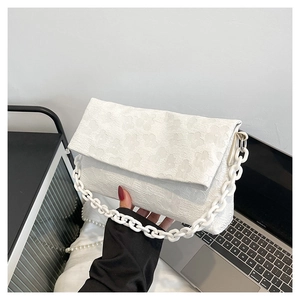Détail d'un sac à main blanc avec texture marguerite 3D et chaîne à gros maillons