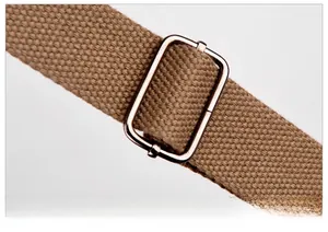 Détail de la bandoulière réglable en toile kaki avec boucle métallique pour sac à main