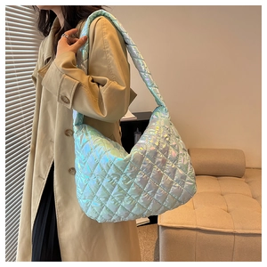 Macro detail of the quilted holographic cloud bag with iridescent blue and green laser texture