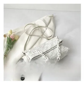 Detail of cream white quilted crossbody bag with chunky chain strap and checkered pattern