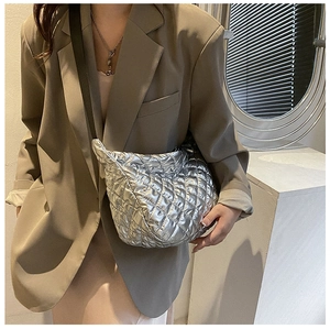 Close-up of metallic silver quilted cloud bag showing puff texture and stitching detail