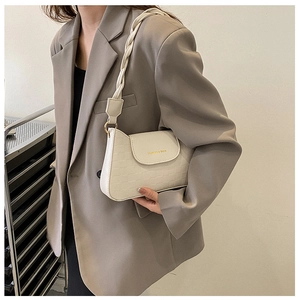 Detail of crocodile embossed cream shoulder bag with stylish woven rope handle strap