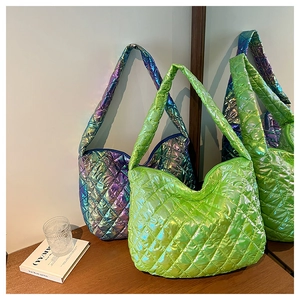Close-up of quilted tote bags in metallic neon green and iridescent purple fabrics