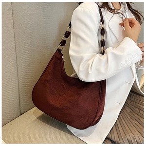 Detail of burgundy frosted leather shoulder bag featuring gold metal rings and retro strap