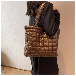Close-up of a large dark brown quilted tote bag with a stylish metallic finish