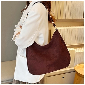 Detail of burgundy matte shoulder bag with metal ring buckle on minimalist white suit