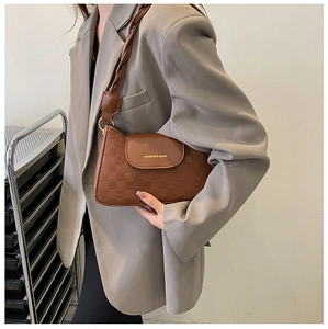 Detail of retro brown crossbody bag with checkerboard texture and twisted shoulder strap