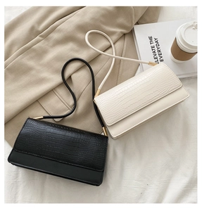 Detail of crocodile embossed flap and smooth leather finish on chic baguette bags
