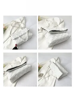 Detail view of white chain bag featuring textured checkerboard fabric and chain strap
