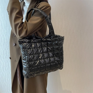 Large black quilted tote bag for women with glossy finish and square stitch patterns